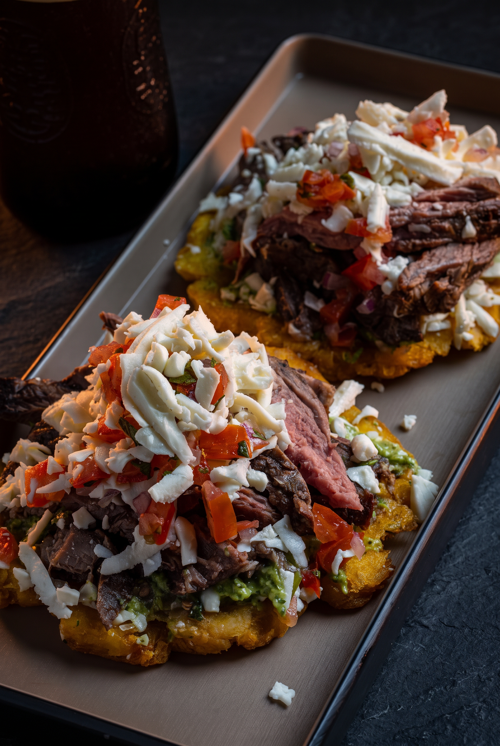 Patacones con carne mechada, queso blanco y pico de gallo